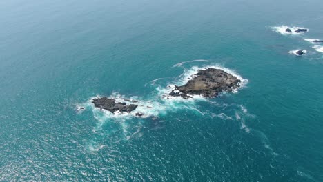 Aerial-view-of-rocky-islands-washed-by-calm-ocean-waves-on-Java-coast-Indonesia