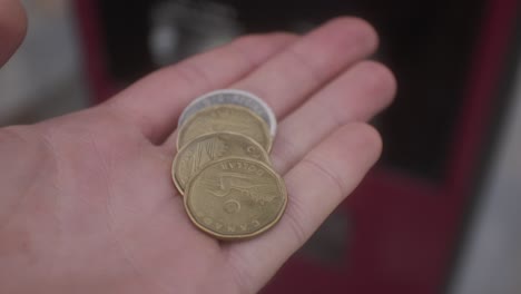 Monedas-De-Uno-Y-Dos-Dólares-Canadienses-En-La-Palma-De-La-Mano