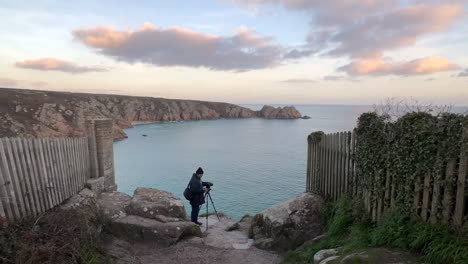 An-Indian-male-photographer-making-preparations-to-click-a-landscape-photograph-at-Porthcurno-Beach