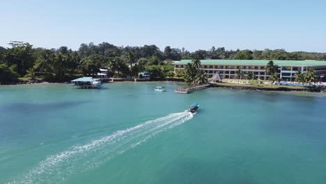Aerial:-Tourism-Tour-boat-returns-to-hotel-beach-resort-dock,-Panama
