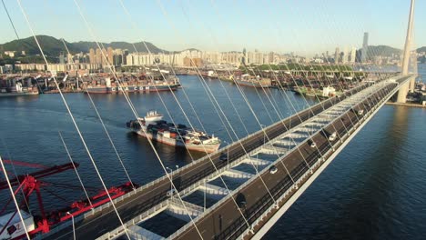 Großes-Containerschiff,-Das-Die-Bucht-Von-Hongkong-Unter-Der-Steinmetzbrücke-Verlässt,-Luftbild