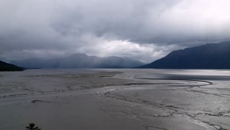 aerial-push-over-trees-to-reveal-cook-inlet-at-low-tide-near-anchorage-alaska