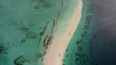 Aerial-drone-shot-of-an-amazing,-heavenly,-paradisiacal-island-with-boats-in-Zanzibar
