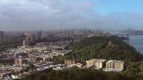 Epic-wide-aerial-truck-across-Upper-Manhattan-NYC-with-a-vista-of-Inwood,-Washington-Heights,-and-Midtown-with-a-storm-over-it