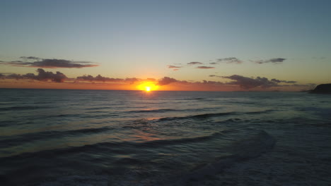 Luftaufnahme-Eines-Wunderschönen-Sonnenaufgangs-über-Einem-Ruhigen-Ozean-Mit-Der-Sonne,-Die-Von-Den-Wellen-Reflektiert-Wird,-In-Miami-Gold-Last,-Australien