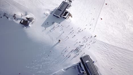 Aerial-view-of-ski-resort-with-people-snowboarding-down-the-hill