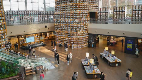 People-move-around-watching-and-choosing-books-in-Starfield-Library-in-Coex-Mall-in-Gangnam-District,-Seoul-city,-Korea---tilting-down-establishing-shot-timelapse