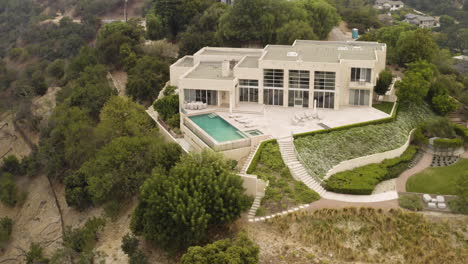 Aerial-view-of-a-Beverly-Hills-modern-mansion-and-the-surrounding-hills