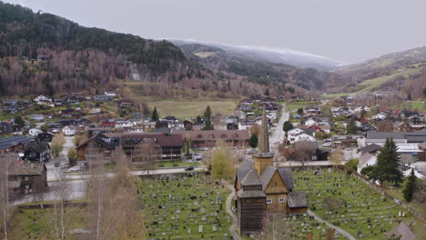 Church-Vaga,-Wooden-Church-with-Graves,-Vagamo,-Norway---aerial-drone-shot