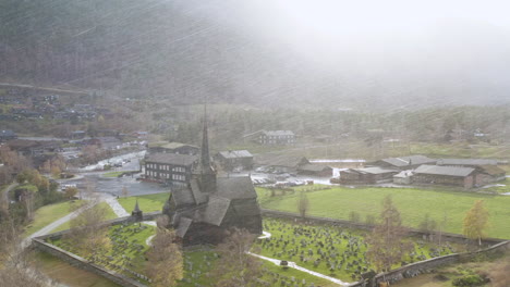 Iglesia-De-Madera-Rodeada-De-Lápidas-Durante-Una-Tormenta-De-Nieve-En-Lom,-Noruega