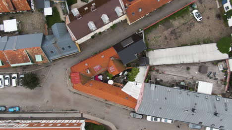 Old-historic-buildings-of-Ystad-city-with-colorful-rooftops,-aerial-ascend-top-down-view