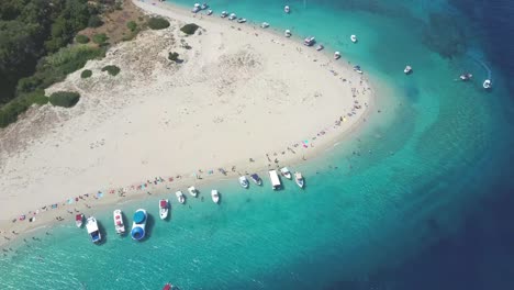 Aerial-drone-view-of-iconic-small-uninhabited-island-of-Marathonisi-featuring-clear-water,-sandy-shore-and-natural-hatchery-of-Caretta-Caretta-sea-turtles,-Zakynthos,-Greece