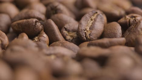 Macro-close-up,-roasted-coffee-beans-spinning-shot