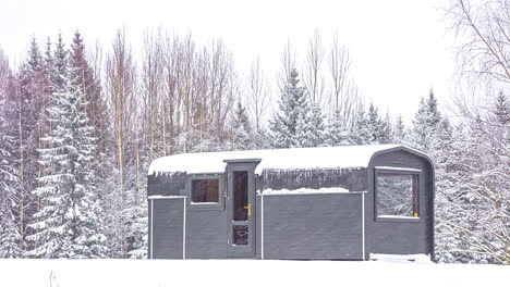Zeitrafferaufnahme-Einer-Holzhüttenwohnung,-Umgeben-Von-Verschneiter-Winterlandschaft-Bei-Schneefall---Stürmischer-Tag-In-Nordeuropa