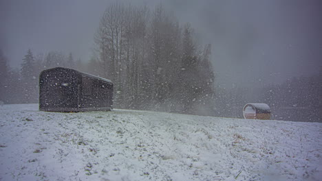 Winter-timelapse-cabin-and-barrel-landscape-during-december-snow-storm-scene-view