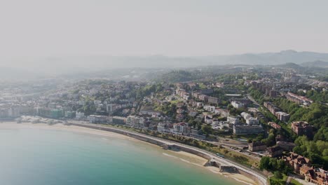 Cityscape-of-San-Sebastian-with-sandy-beach-and-blue-sea-coastline,-aerial-drone-view