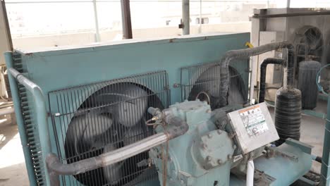 Two-Spinning-Giant-Enclosed-Industrial-Fans-Inside-Factory-In-Pakistan