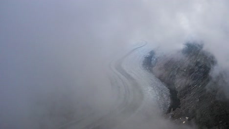 Aerial-reveals-view-of-Aletsch-glacier-covered-in-Fog,-Switzerland