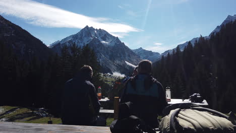3-Austrian-men-sitting-by-the-side-table-with-mountain-view-in-the-background