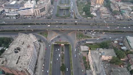 Aerial-Shot-Of-Cars-Driving-On-The-Kalma-Chowk-Underpass,-Lahore-Skyline-In-Pakistan