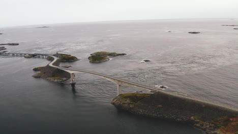 Vista-Del-Puente-Storseisundet-Y-La-Carretera-Del-Océano-Atlántico-En-Un-Día-Nublado-En-Noruega---Disparo-De-Drones
