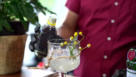 Bartender-latin-mexican-preparing-mixology-cocktail-with-tonic-water-and-chamomile-in-slow-motion-gin-glass