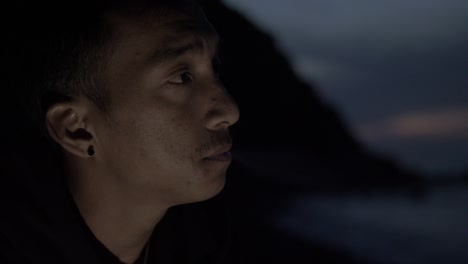Junger-Nepalesischer-Mann,-Der-Nachts-Allein-Am-Strand-Sitzt-Und-Zigarette-Raucht