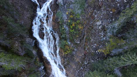 Dynamic-drone-video-of-a-rocky-wall-where-a-waterfall-runs