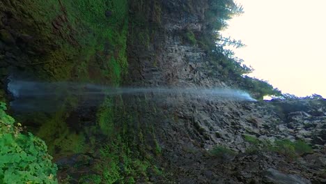 Vertikale-Aufnahme-Eines-Wasserfalls-Mit-Einer-Scharfen-Felswand