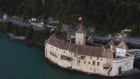 Aerial-shows-Chillon-castle-in-the-evening-close-from-Lausanne,-Switzerland