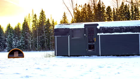 Exterior-Of-A-Glamping-Cottage-On-Snow-filled-Landscape-In-Wintertime