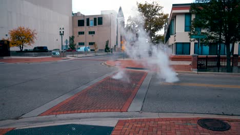Steam-rising-from-below-a-city-street-in-Lansing,-Michigan