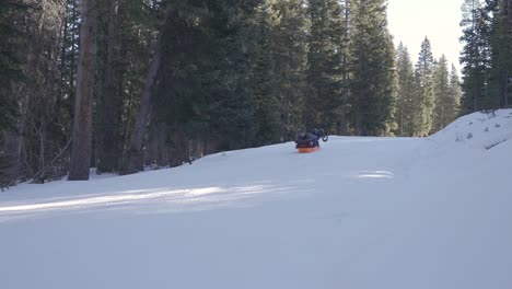 Man-Riding-Sled-down-a-hill-in-the-winter-while-camping