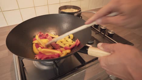 Stir-Frying-Of-Red-And-Yellow-Sweet-Peppers-In-A-Wok