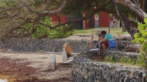 Ein-Paar-Sitzt-Auf-Einer-Felswand-Mit-Blick-Auf-Das-Wasser-Und-Macht-Ein-Picknick-In-San-Juan,-Puerto-Rico