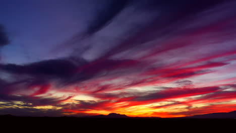 La-Luz-Del-Amanecer-Llena-El-Cielo-Con-Nubes-Coloridas-Con-El-Paisaje-Del-Desierto-De-Mojave-En-Silueta---Gran-Angular,-Zoom-Lento
