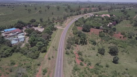 Aerial:-Large-pineapple-plantation-off-curving-highway-in-East-Africa