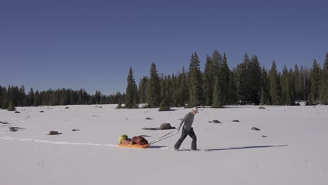 Man-in-nature-with-snowshoes-and-his-sled-exploring-the-wild