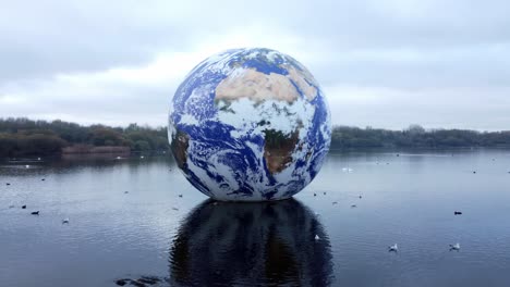 Luke-Jarram-floating-earth-art-exhibit-aerial-view-Pennington-flash-lake-nature-park-push-in-from-right