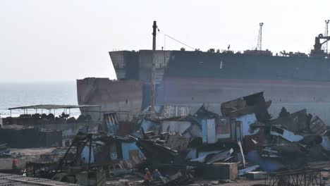 View-Of-Gadani-Ship-Breaking-Yard-With-Large-Ship-Moored-In-Background-In-Hazy-Air