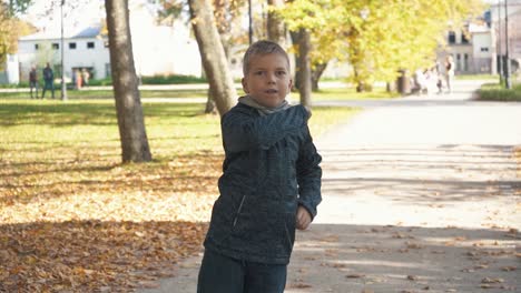Ein-Junge-Im-Herbstlichen-Farbenfrohen-Park-Spielt-Mit-Einem-Papierflieger