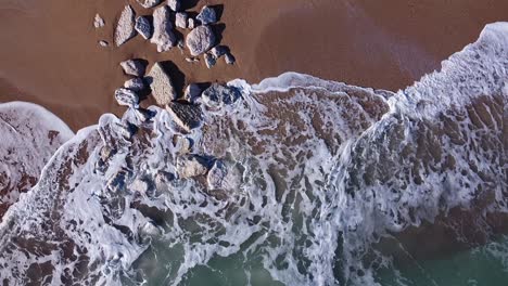 aerial-view-of-an-Italian-coastline,-morning-light,-bird's-eye-view---rocks-on-the-beach-hit-by-the-waves-of-the-Adriatic-Sea