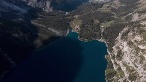 High-circling-drone-shot-over-blue-lake-Oeschinen-Kandersteg-Switzerland