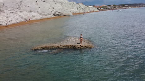 Woman-walks-on-the-coastline-of-Clay-beach,-Cephalonia,-Kefalonia-in-Greece