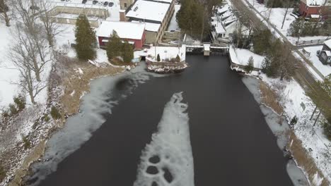 Aerial-Flyover-Of-Historic-Mill-And-Frozen-Pond-During-Winter,-Alton
