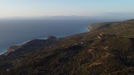 Aerial:-Hill-island-forest-with-vast-blue-Sea-at-Lefkada,-Greece---drone-flying-top-wide-shot