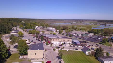 Panning-aerial-of-buildings-and-street-traffic-in-Montague,-Michigan
