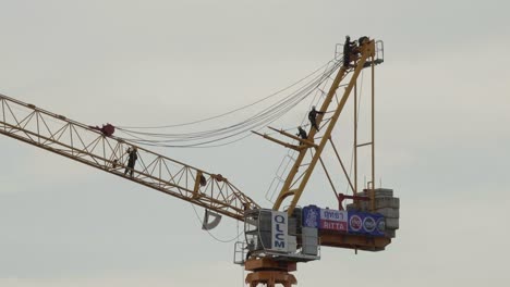 A-team-of-specialised-engineers-rigging-up-a-tall-crane-on-a-construction-project-in-Pathum-Thani,-Thailand