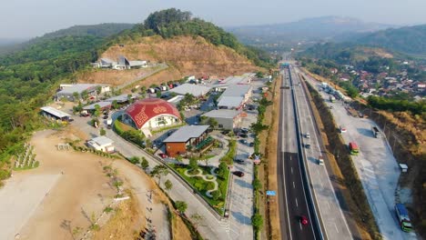 Highway-near-Salatiga,-Indonesia-with-rest-place-for-drivers-with-mosque,-aerial