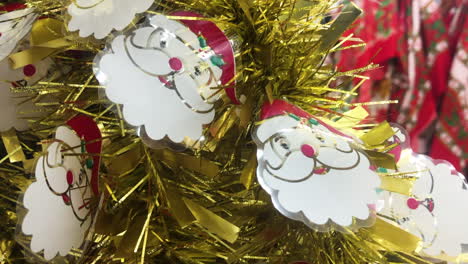 Gold-Christmas-tinsel-with-Santa-Claus-decoration-for-sale-in-a-festive-store